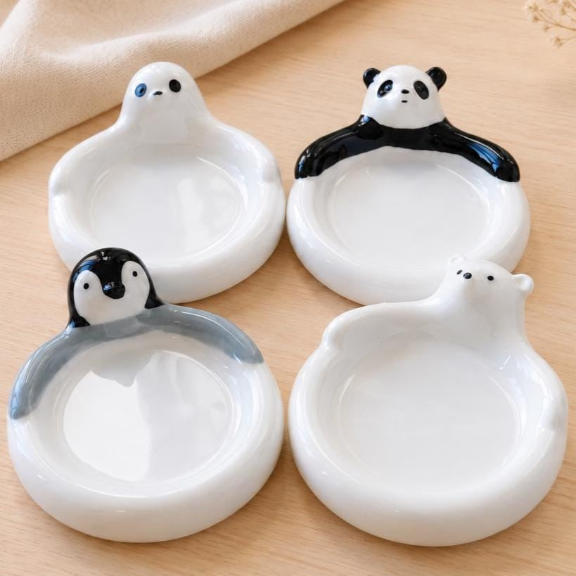 Four ceramic animal-shaped bowls on a wooden surface
