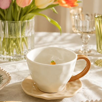 Cute capybara ceramic teacup and saucer styled on an elegant dining table with flowers, featuring a hidden 3D capybara head topped with yuzu inside the cup.