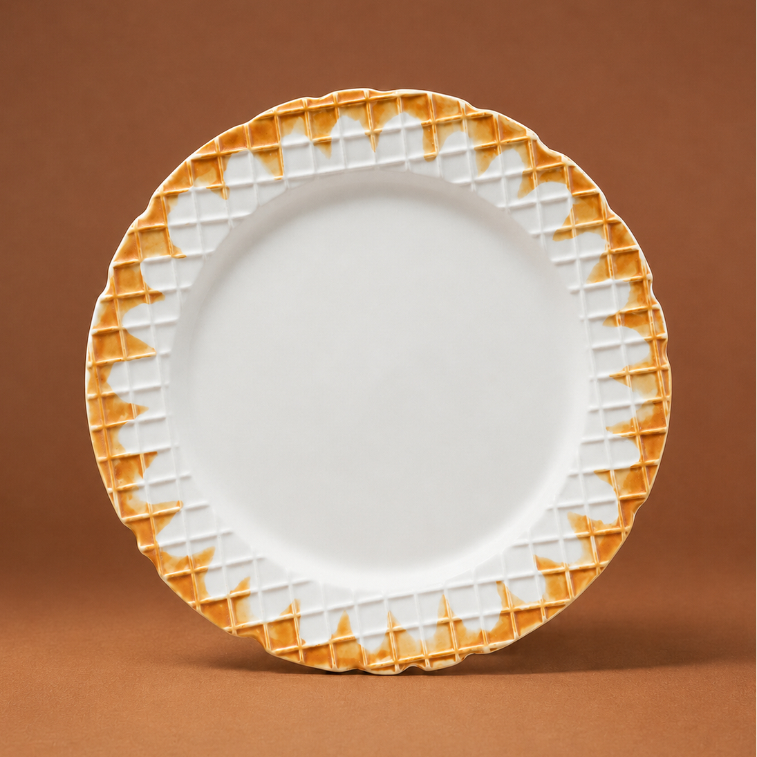 A white ceramic plate with a textured, scalloped orange-gold rim, standing upright against a solid brown background.