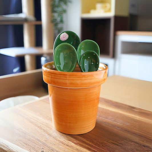 Green ceramic cactus measuring spoons and cup set on a kitchen counter